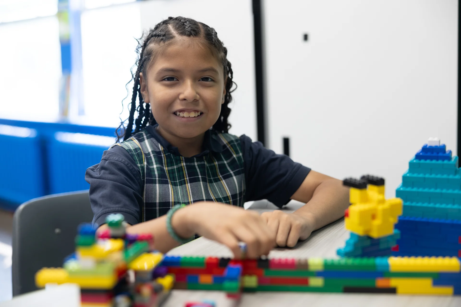 student smiling while working on legos