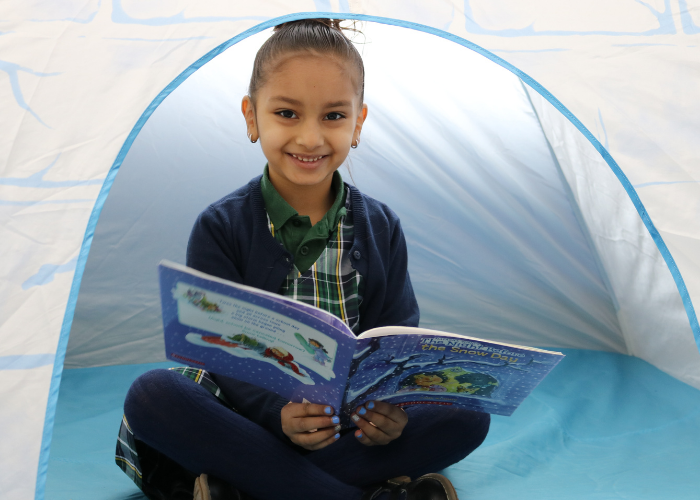 Student reading in a tent